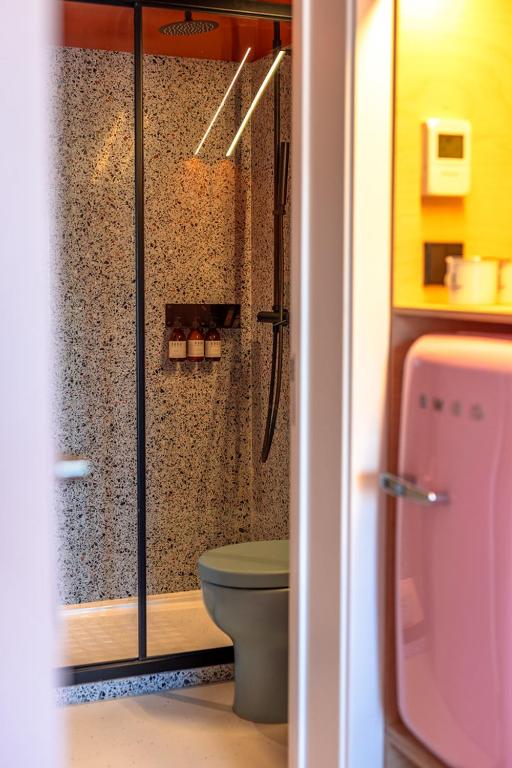 A bathroom view centred on the glass shower and terrazzo walls.