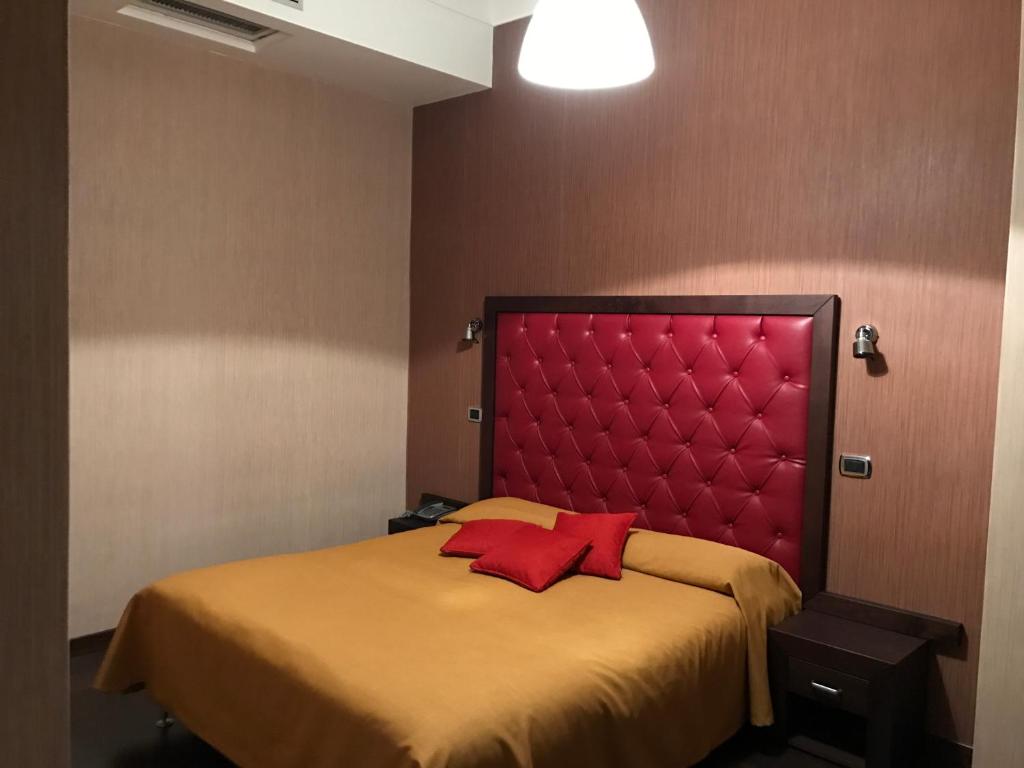 a bed with a red headboard in a room at Hotel Fontana Del Re in Ariano Irpino