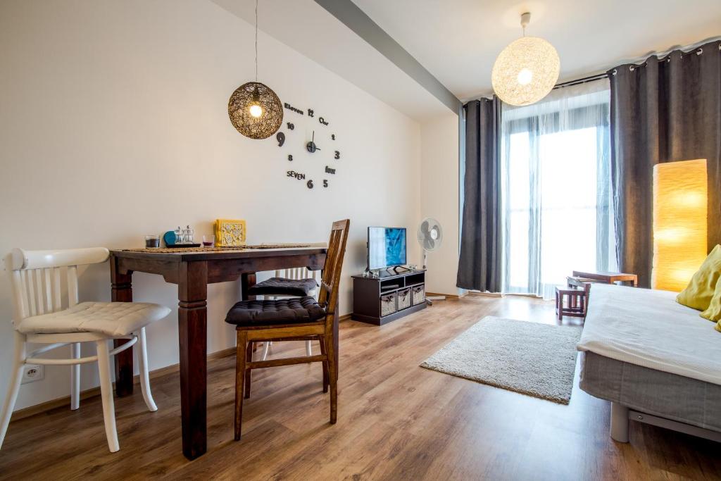 ein Wohnzimmer mit einem Schreibtisch und einem Tisch in der Unterkunft Old Town modern apartment by Kovee in Bratislava