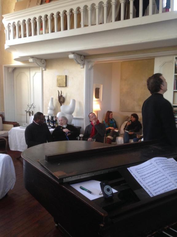un grupo de personas sentadas en una habitación con un piano en Church Des Artistes, en Kingston