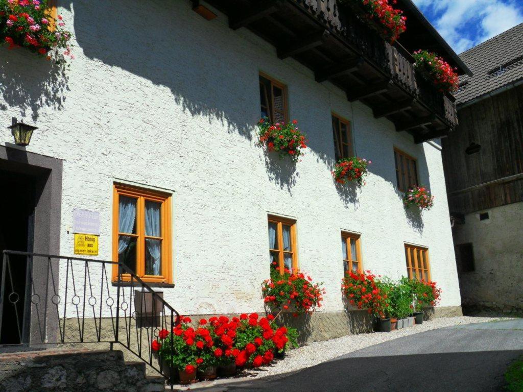 ein weißes Gebäude mit Blumen auf der Seite in der Unterkunft Haus Waldblick in Weissensee