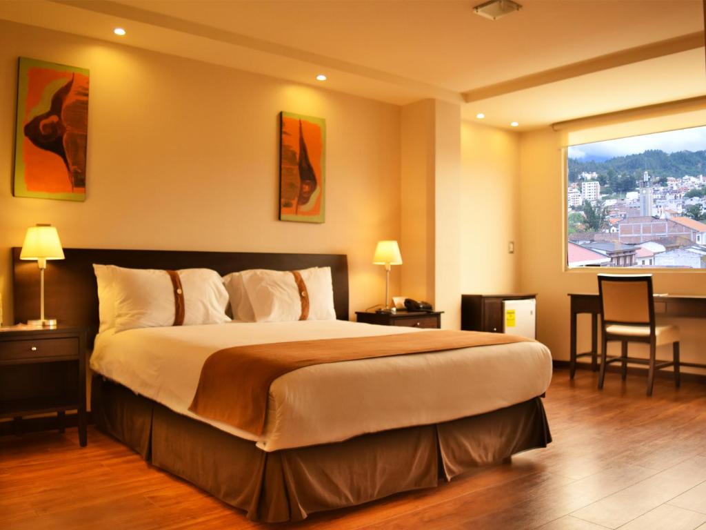 a bedroom with a large bed and a large window at Zamorano Real Hotel in Loja