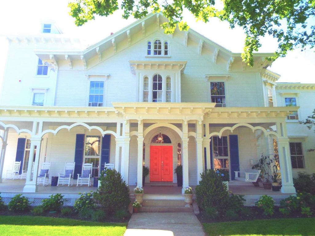 uma grande casa branca com uma porta vermelha em The Bayberry em Newport