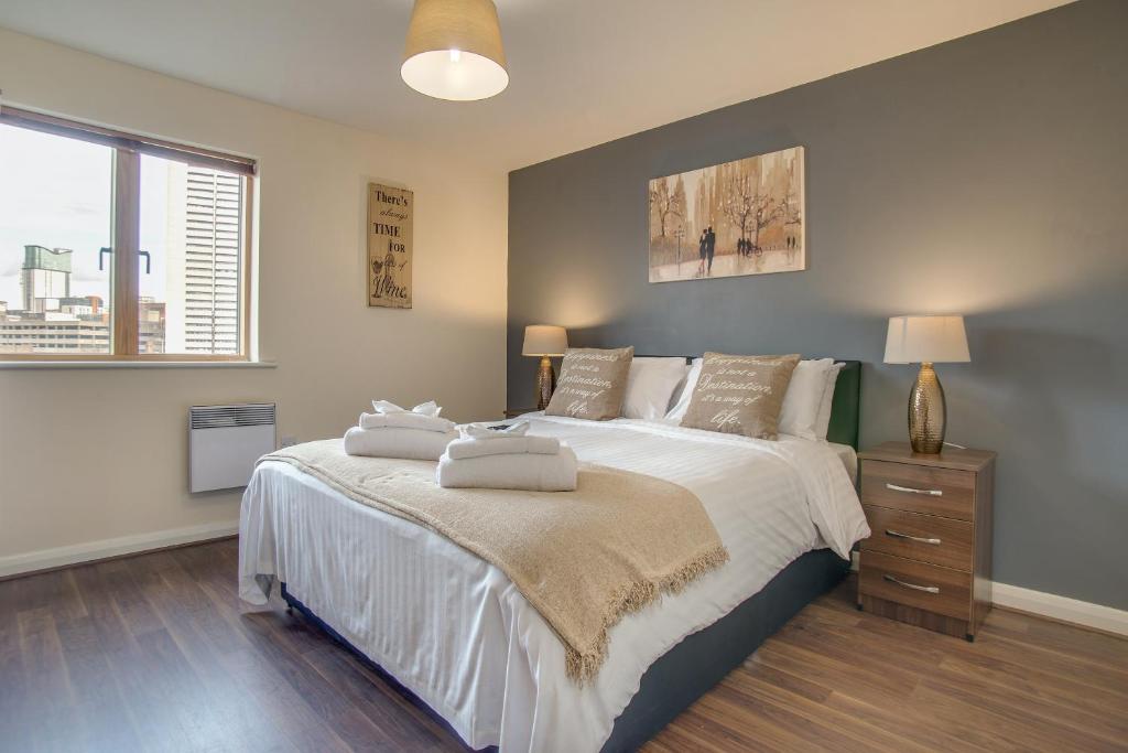 a bedroom with a large bed with two towels on it at Mica Point City Centre Apartment in Birmingham