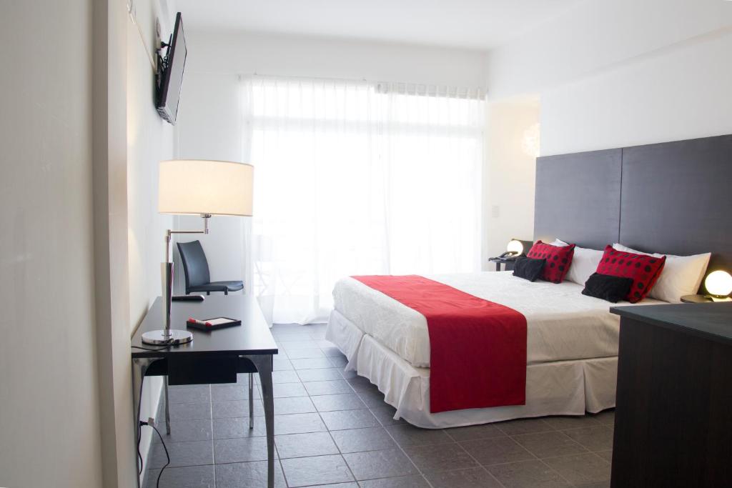 Let Sun Hotel Boutique في بوينس آيرس: غرفة نوم بسرير كبير مع بطانية حمراء