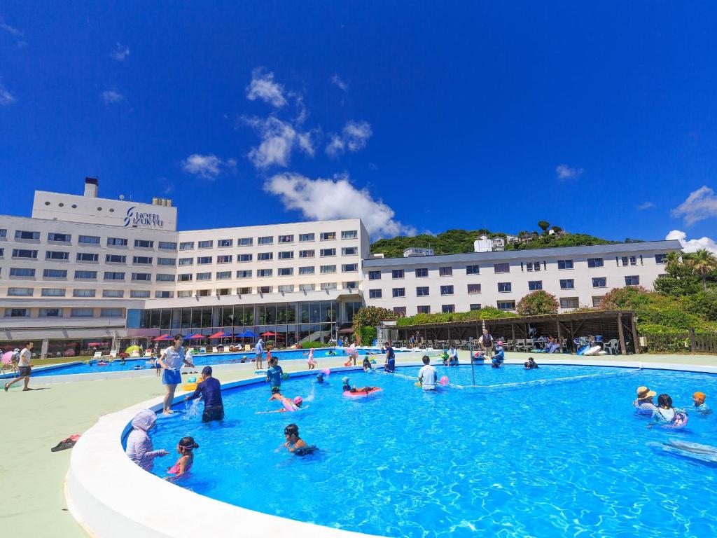 a group of people in a large swimming pool at Hotel Izukyu in Shimoda