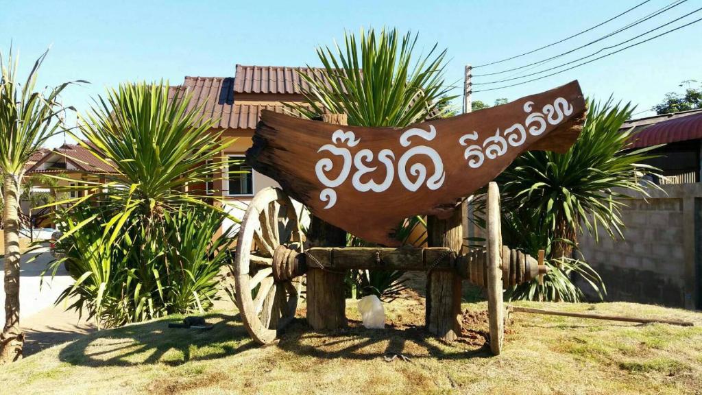 a statue of a wooden cart in front of a house at Ouidee Resort in Na Noi
