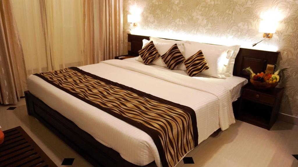 a bedroom with a large bed with two pillows at Cafe Aroma Inn in Kandy