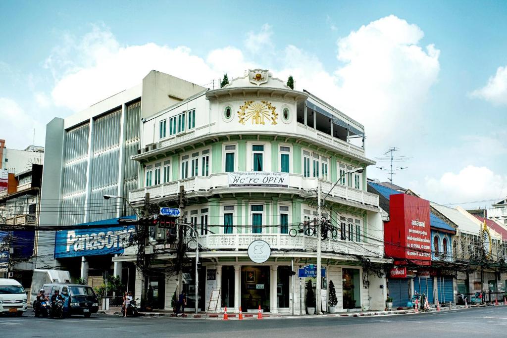 a building with a clock on the top of it at Cacha Bed in Bangkok
