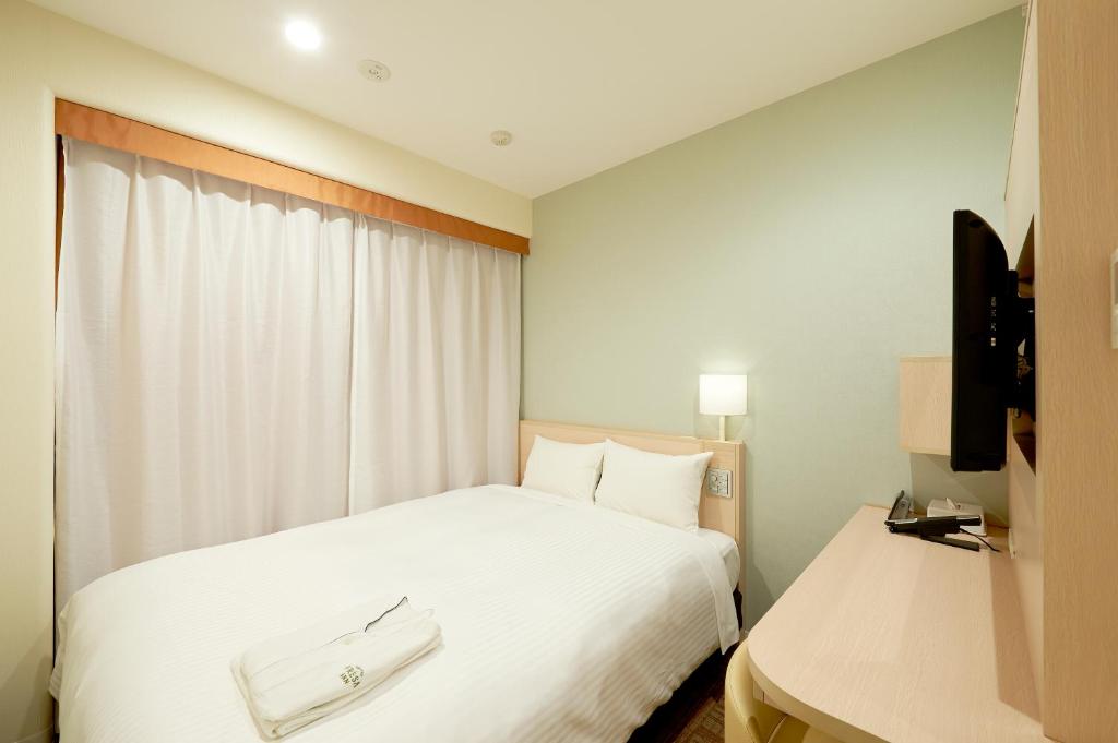 Postel nebo postele na pokoji v ubytování Sotetsu Fresa Inn Tokyo Tamachi
