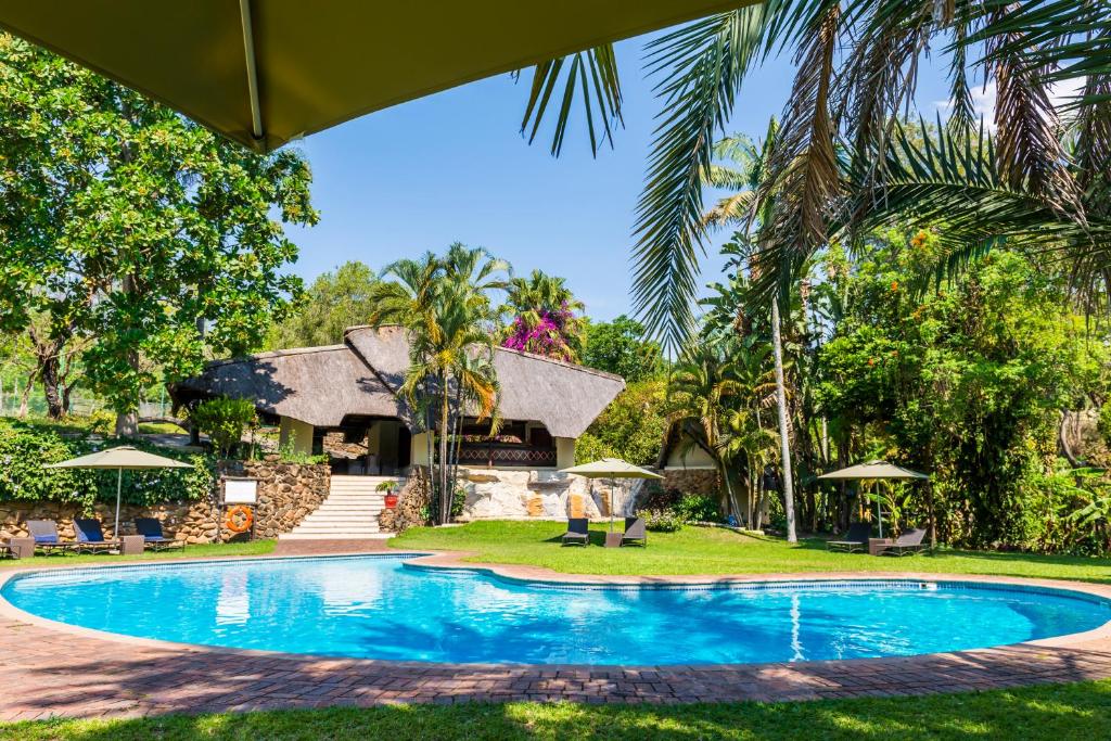 a swimming pool in front of a house at ANEW Resort Hazyview Kruger Park in Hazyview