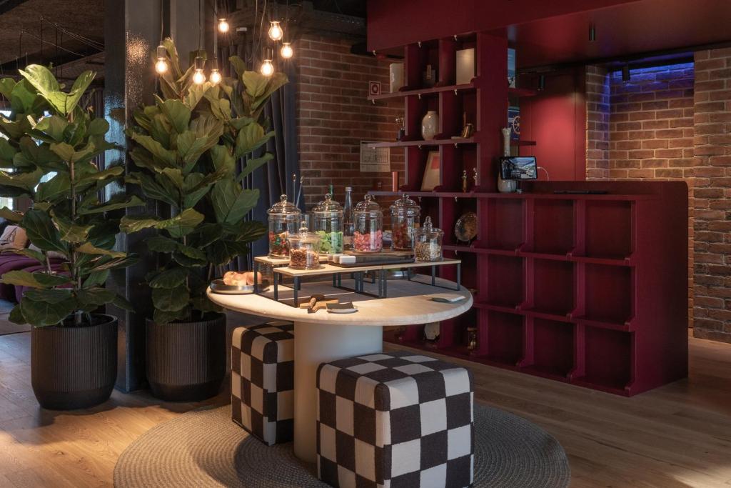 A design-forward lounge corner with a drinks table and bold checkerboard stools.
