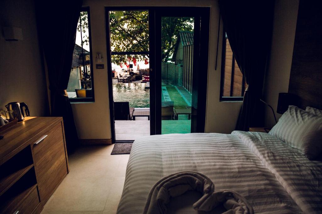 a bedroom with a bed and a sliding glass door at 15 Palms Beach Resort in Ko Chang