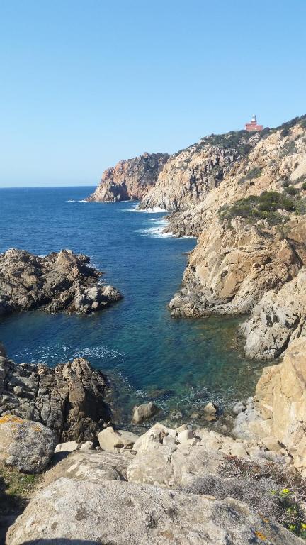 a view of the ocean from a rocky shore at L'Onda Blu in Domus de Maria