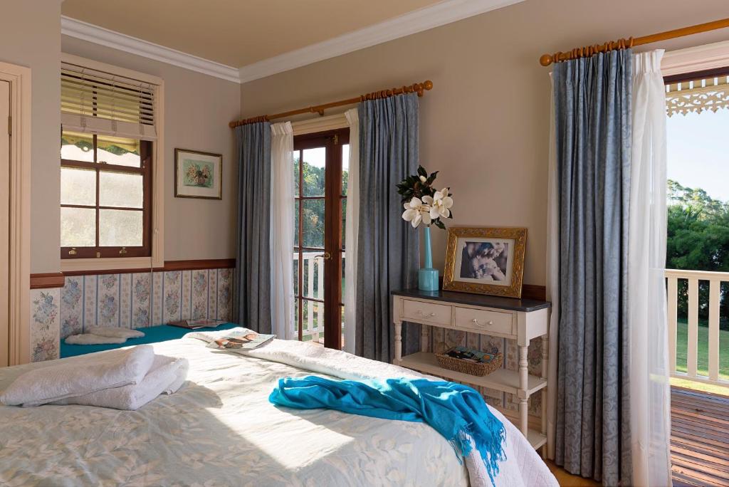 um quarto com uma cama grande e uma janela em Middleton House Maleny em Witta