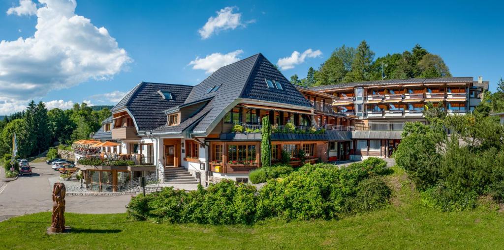 a large house with a gambrel roof at Albtalblick Ihr Wellness- & Wanderhotel in Häusern