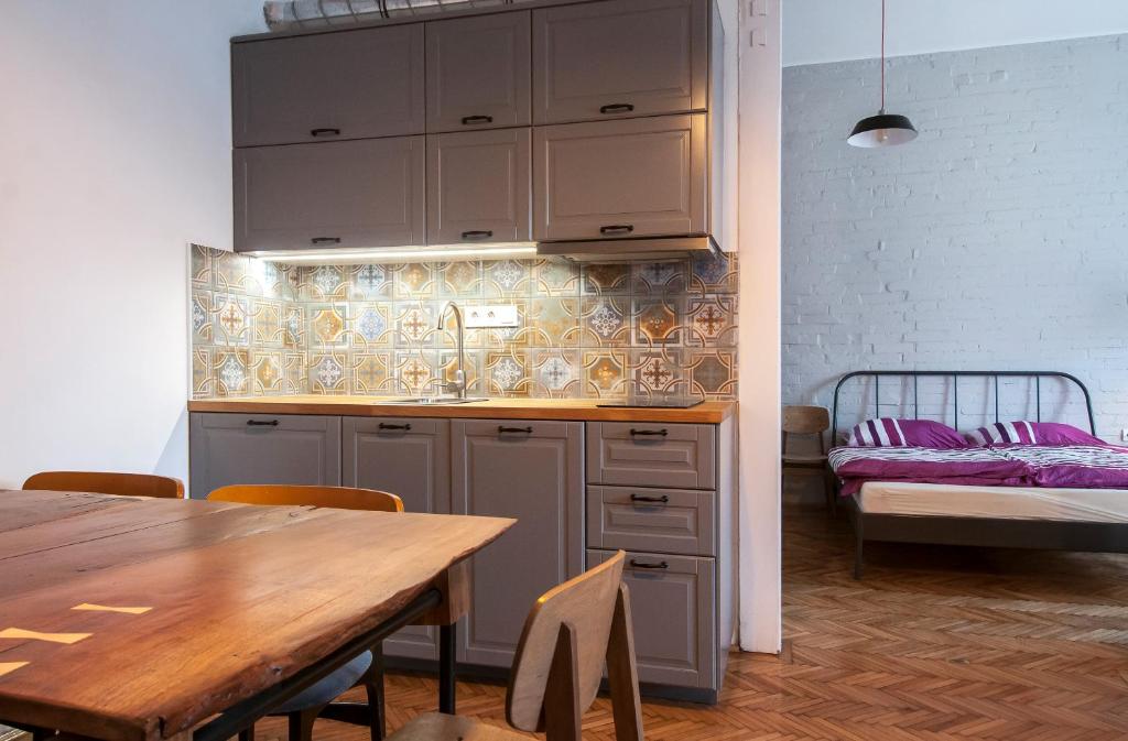 a kitchen with a wooden table and a dining room at Stylish downtown apartment in Budapest