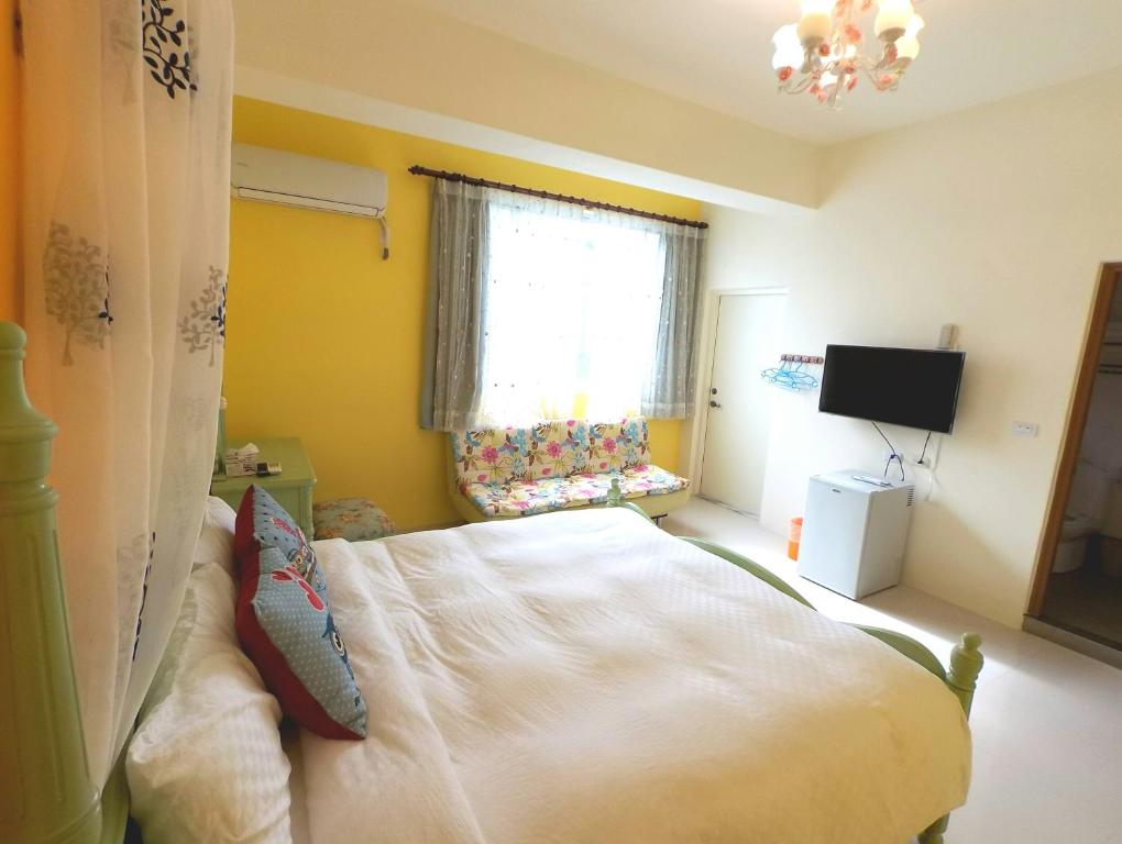 a bedroom with a bed and a television in it at Eik Forest B&amp;B in Taitung City