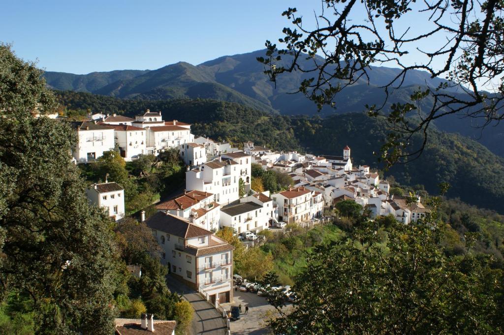 un pueblo en una colina con montañas en el fondo en Apartamentos Rurales Jardines del Visir en Genalguacil