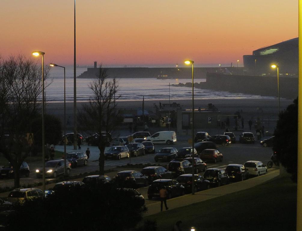 un estacionamiento lleno de coches al atardecer en Porto 1 Bedroom Beach Apartment, en Matosinhos