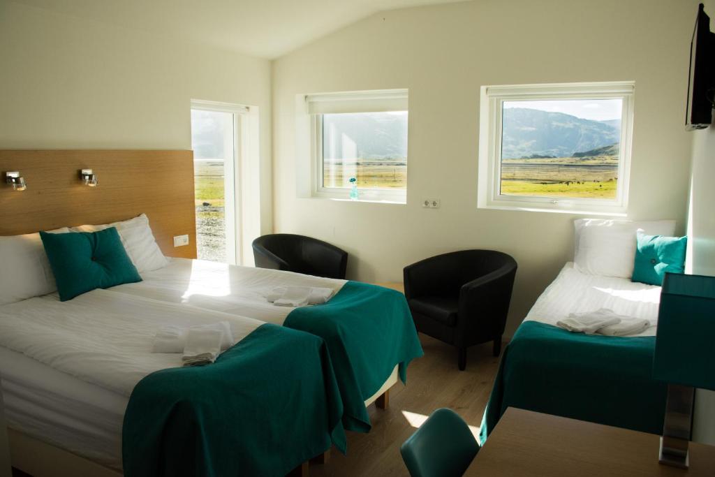a hotel room with two beds and two windows at Glacier World - Hoffell Guesthouse in Hoffell
