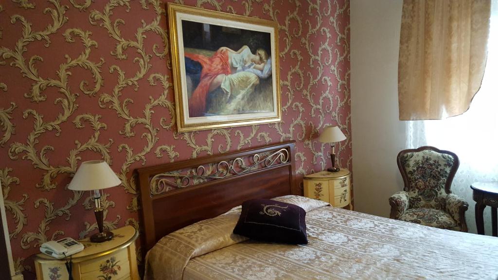 1 dormitorio con 1 cama y una foto en la pared en Hotel Royal, en Alessandria