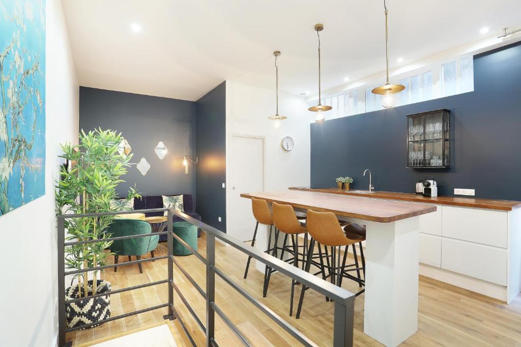 Il dispose d'une cuisine et d'un coin repas avec un bar et des tabourets. dans l'établissement Rent a Room - Charon 3, à Paris