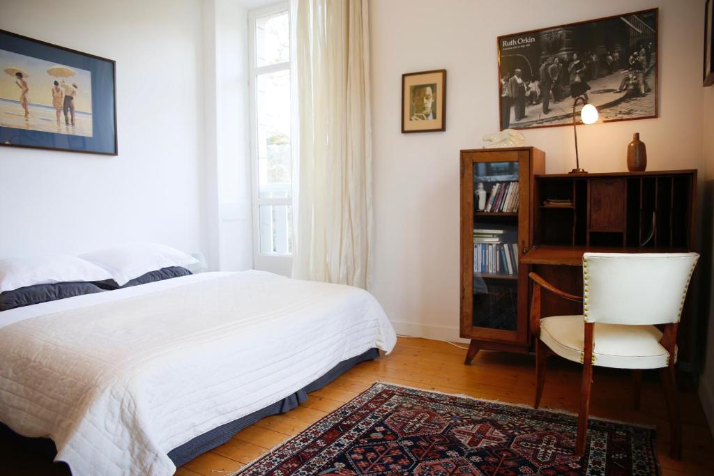 a bedroom with a bed and a chair and a window at Château de Penfrat in Gouesnach