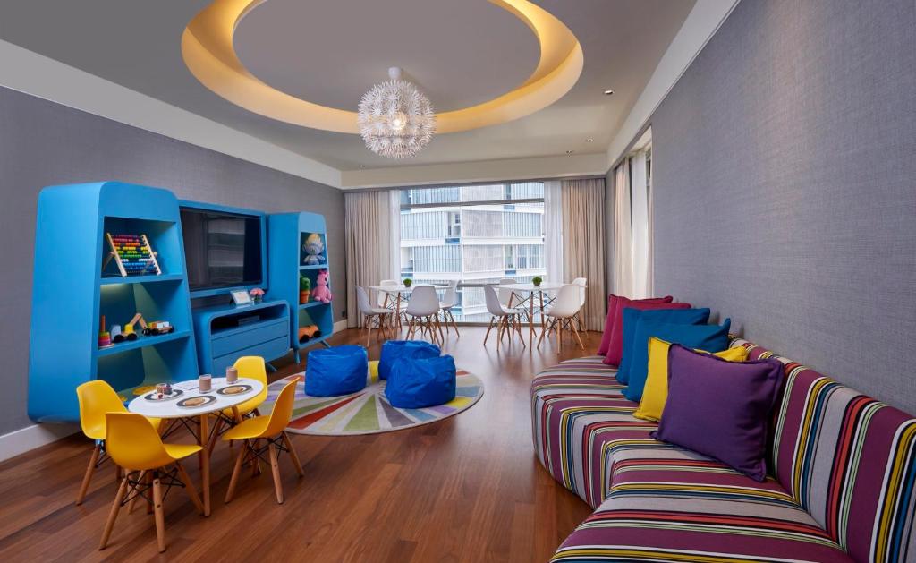 A colorful family-style living room with a sofa, children’s play area and window-side table.