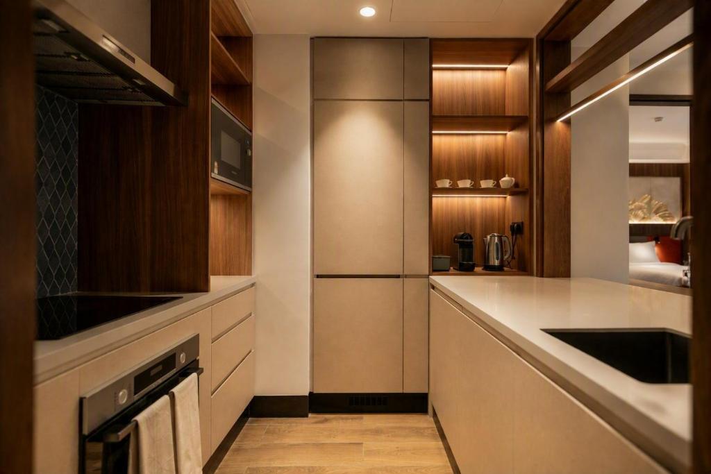 A compact, fully fitted kitchenette with built-in appliances and a long counter.