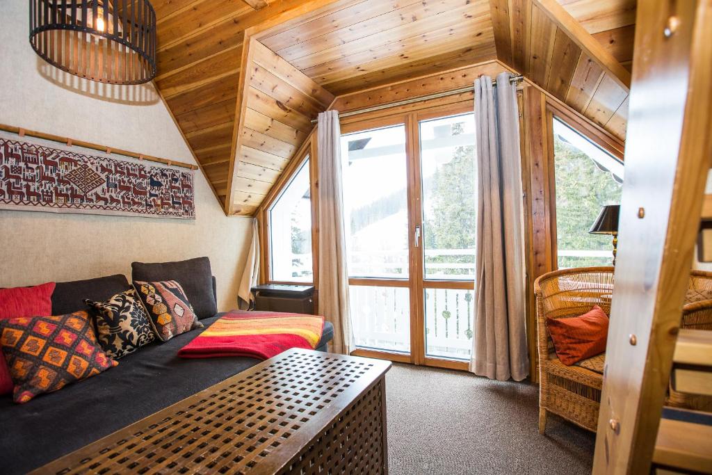 a living room with a couch and a large window at Hotell Fjällgården Ski-In Ski-Out in Åre
