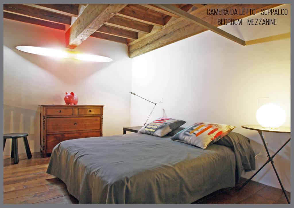 a bedroom with a bed and a dresser in a room at Appartamento Il Fregio in Pistoia