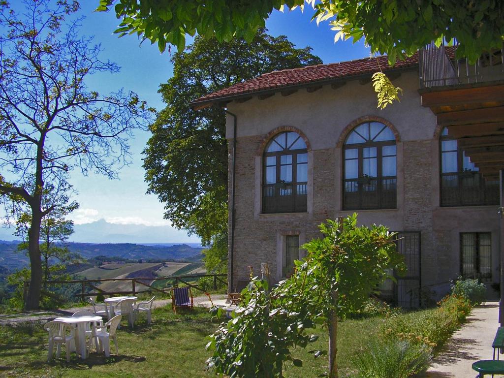 a building with tables and chairs in front of it at Casa Branzele in Trezzo Tinella