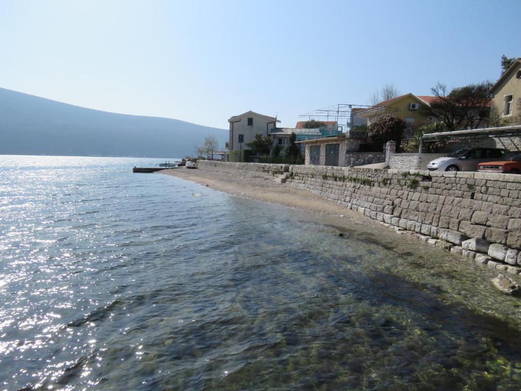 a beach next to the water with houses at Rooms Beba in Herceg-Novi