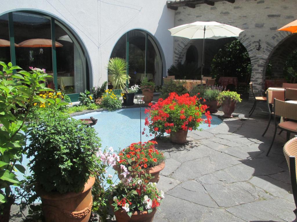 a garden with potted plants and flowers in pots at Hotel Arcadia in Ascona