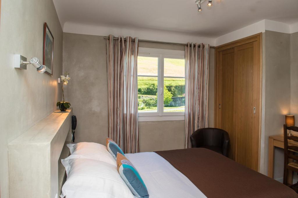 Postel nebo postele na pokoji v ubytování Logis Hotel Ur-Hegian