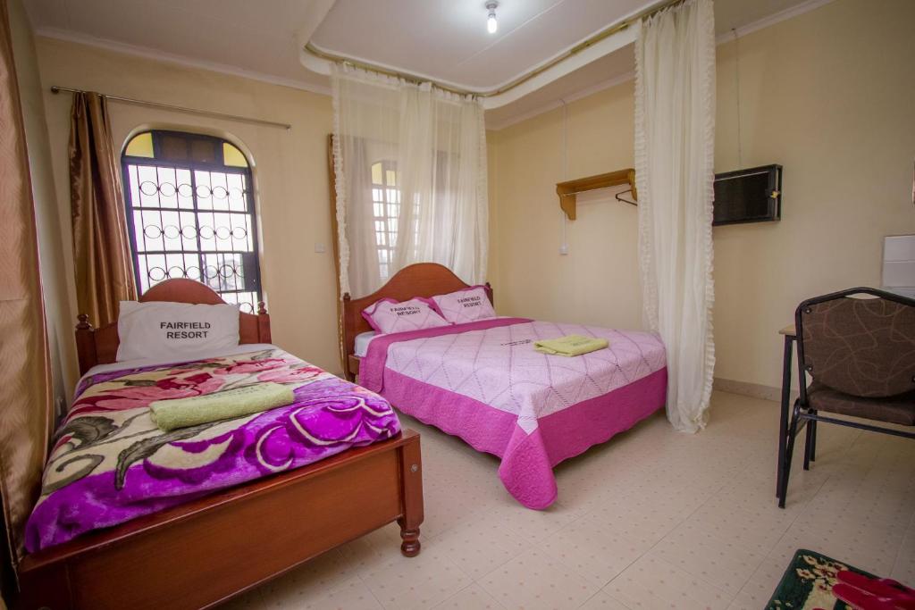 納庫魯的住宿－Fairfield Resort，一间卧室配有两张床和椅子