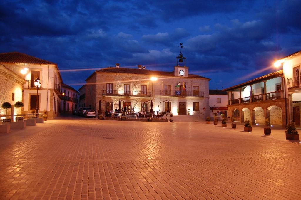una plaza de la ciudad con un edificio con una torre de reloj en Hotel Los Usías, en Dos Torres