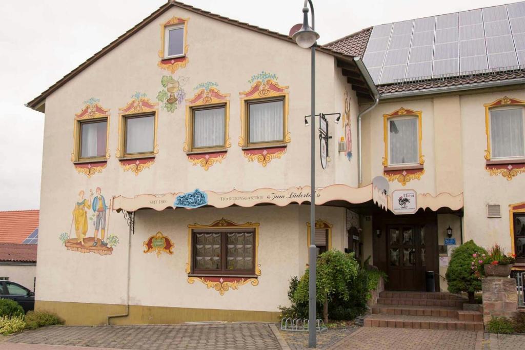 ein Gebäude mit einem Gemälde auf der Seite in der Unterkunft Traditionsgasthof Zum Luedertal in Bimbach