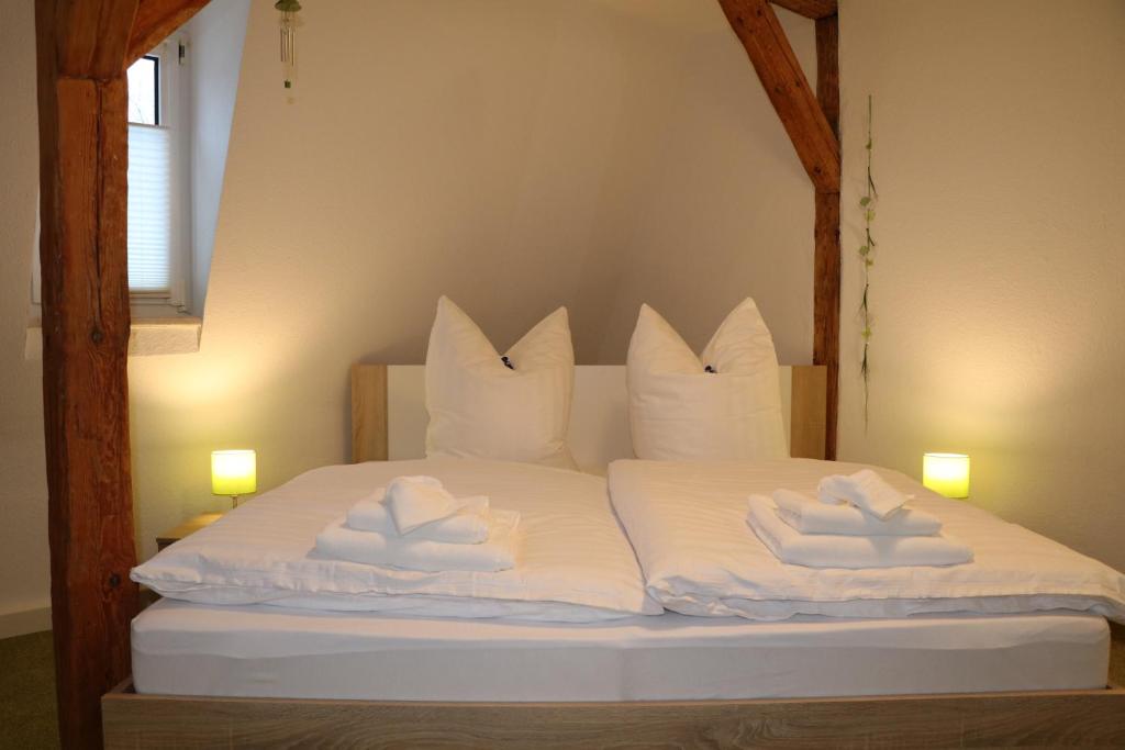 a bed with white sheets and pillows on it at Fewo Friedrichsruh in Bad Elster