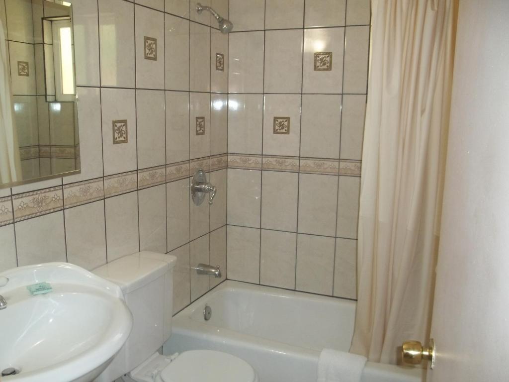 a bathroom with a sink and a toilet and a tub at Hacienda Motel in Yuma