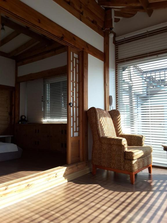 ein Wohnzimmer mit einem Stuhl und einem Fenster in der Unterkunft Yettle Hanok Stay in Gyeongju