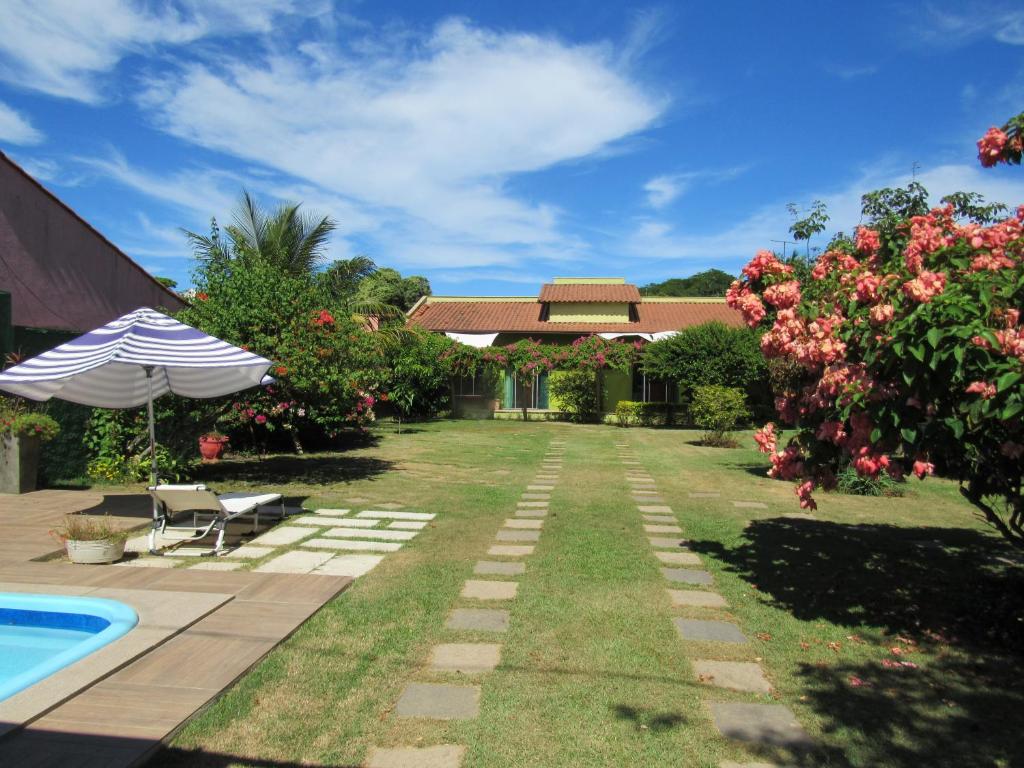 un patio con piscina y una casa en Pousada Mangas en Manguinhos