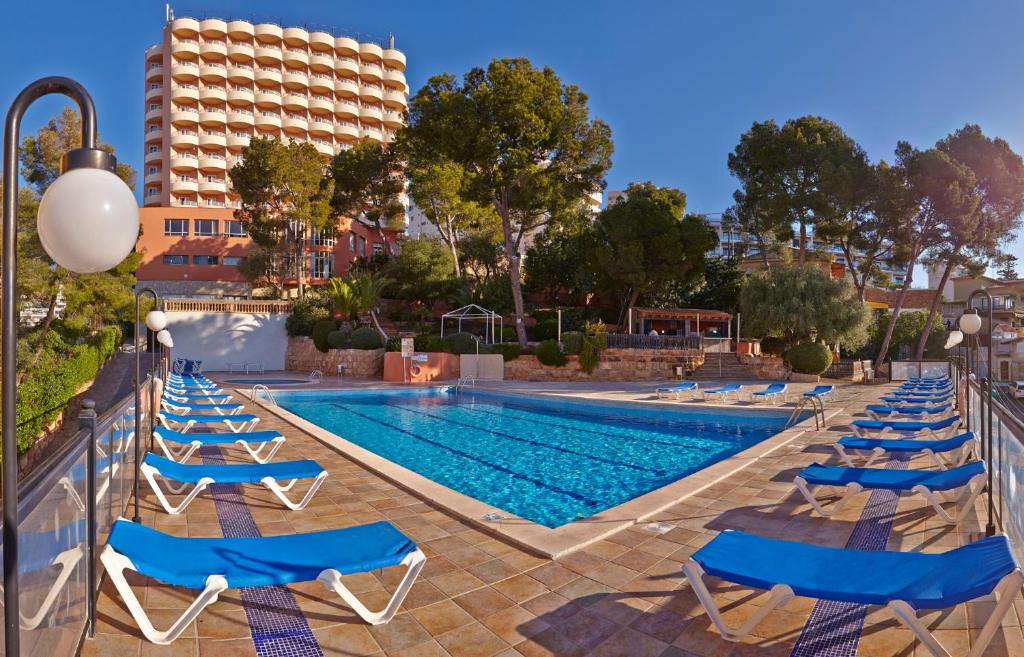 a pool with chairs, tables, and chairs in it at MLL Blue Bay in Palma de Mallorca