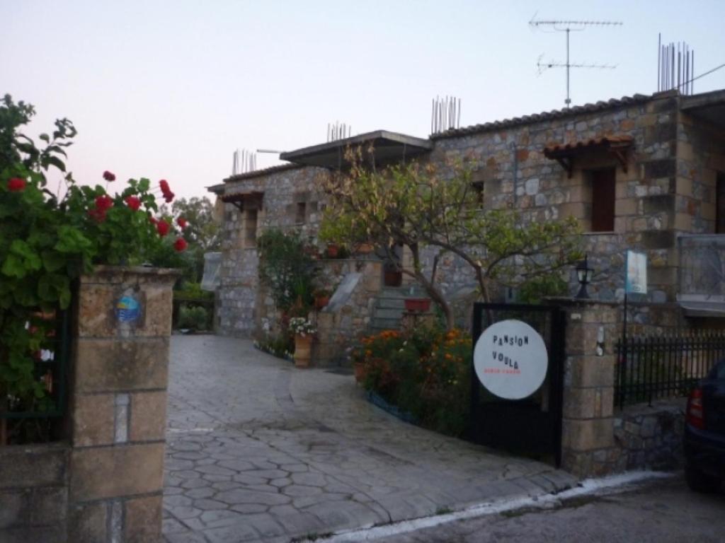 a stone building with a gate with a sign on it at Voula Pansion in Kardamili