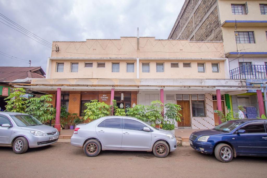 três carros estacionados em frente a um edifício em Sunshine Hotel Tengecha em Kericho