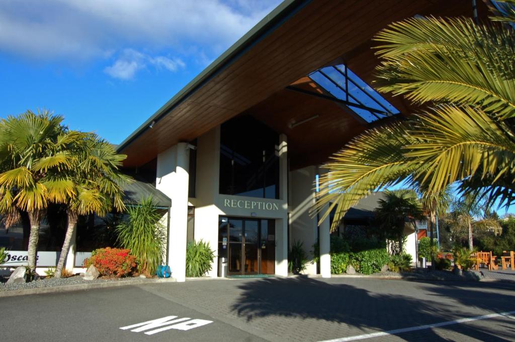 a building with palm trees in front of it at Lakeland Resort Taupo in Taupo
