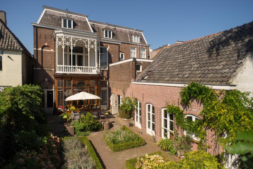 een oud huis met een tuin ervoor bij Boutique Hotel De Blauwe Pauw in Den Bosch