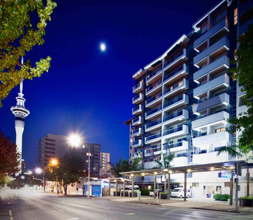 a city street with a tall building and a tower at VR Auckland City in Auckland