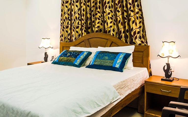 1 dormitorio con 1 cama con 2 almohadas azules en Eve Resort, en Patnem